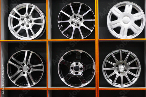 wall of alloy car wheels and pneumatic tires in store. seasonal wheel storage © kalinichenkod