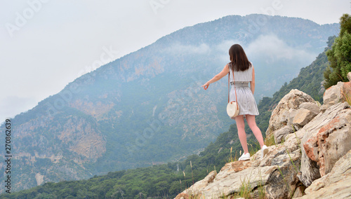 The girl shows her finger away in mountains