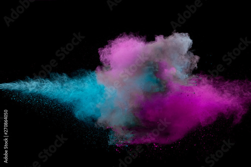 Colored powder collision on black background. Freeze motion.