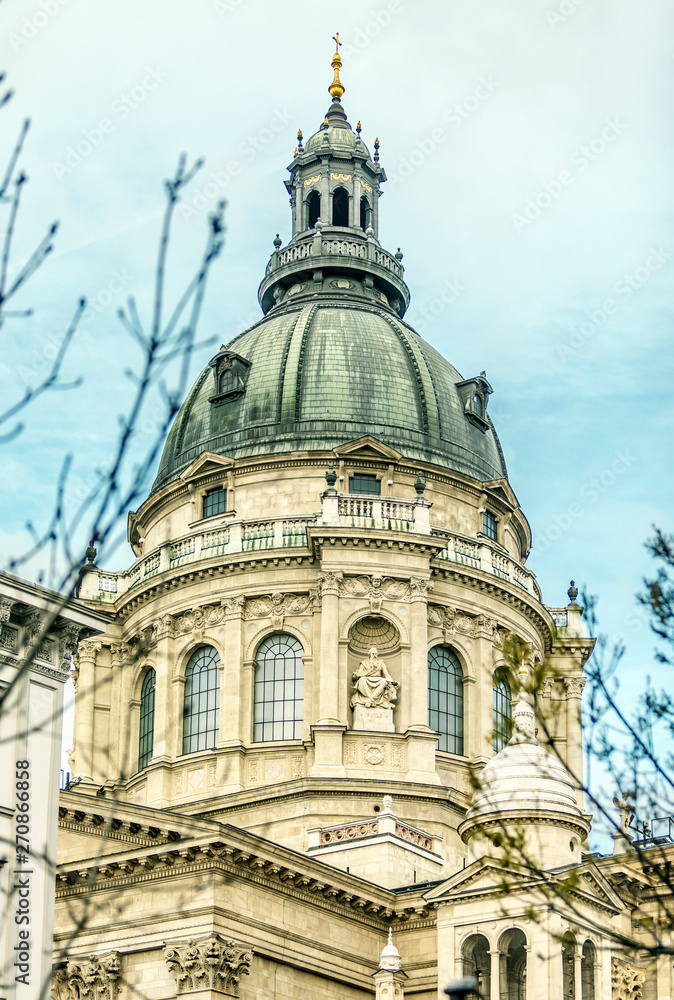 St. Stephen's Basilica. Landmark with grey baroque dome and small sculptures of people, Budapest