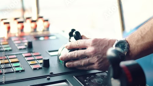 Hand of marine officer operationg bridge ship equipment of offshore dp vessel thruster pitch propellers telegraph handles radio, navigation devices photo