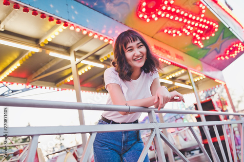 Beautiful asian girl in an amusement park, smiling