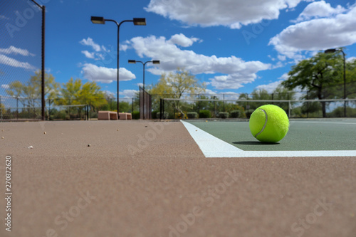 Tennis Ball sitting on a court in a Park