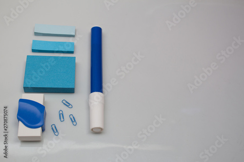 Materials on white table, pen, message blocks, paper clips, rubber and page markers