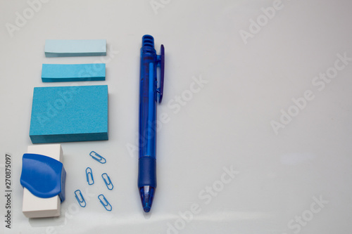 Materials on white table, pen, message blocks, paper clips, rubber and page markers