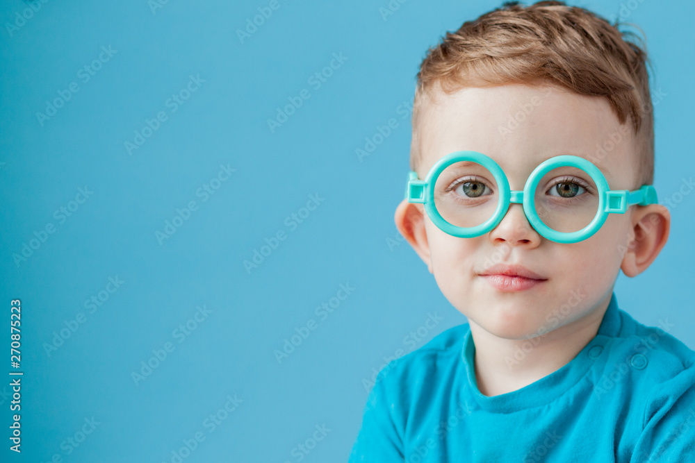 Portrait of a little boy in toy glasses on blue background Portrait of a little boy in toy glasses on blue background