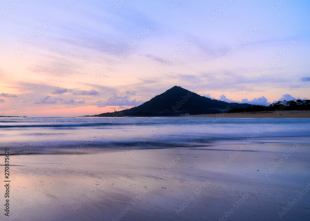 Beach of moledo at the end of the day, with a view to trega mountain on spanish side of the border. Low tide displaying the sandy beach on a cloudy day.