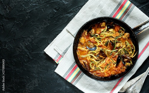 Keto Pasta Zucchini (noodles) Zoodles Spaghetti With Mussels In Tomato Sauce In A Frying Pan. Low-Carb keto. Spaghetti Tarantina. top view. copy space. space for text. recipes for fatty protein foods  photo