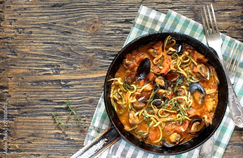 Keto Pasta Zucchini (noodles) Zoodles Spaghetti With Mussels In Tomato Sauce In A Frying Pan. Low-Carb keto. Spaghetti Tarantina. top view. copy space. space for text. recipes for fatty protein foods  photo