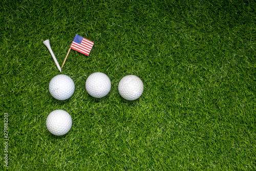 Golf ball with American flag on green grass