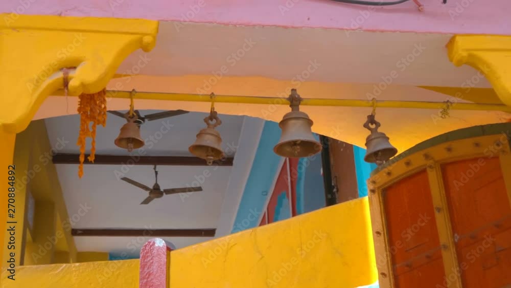 The entrance to the Indian temple is very colorful, with bells hanging above the doors, Rishikesh, India. Shot in motion The entrance to the Indian temple is very colorful, with bells hanging above the doors, Rishikesh, India. Shot in motion