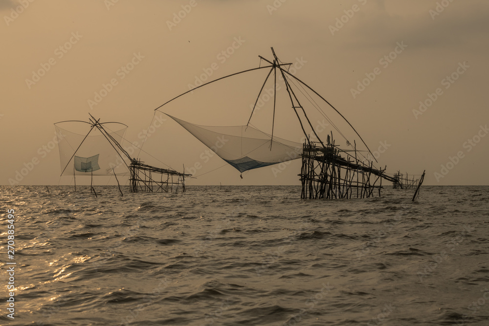Fishing traps or square dip net in lake is local fishery with sunrise background at Pakpra Phatthalung province in famous tourist to travel at southern of Thailand