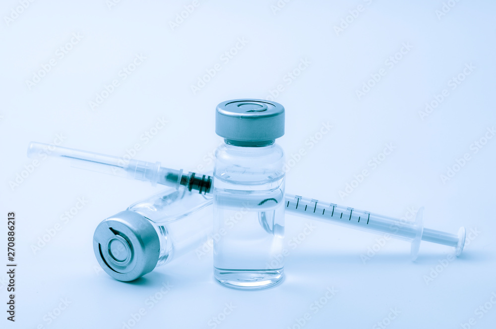 © Victor Moussa - Vaccines, botulinum toxin and insulin ampules concept theme with glass vials with clear liquid next to a syringe and a hypodermic needle isolated on white background © Victor Moussa - Vaccines, botulinum toxin and insulin ampules concept theme with glass vials with clear liquid next to a syringe and a hypodermic needle isolated on white background