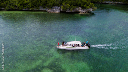 Aerial photography view of Wakatobi (Wangi-Wangi, Kaledupa, Tomia & Binongko) islands with a white boat, Southeast Sulawesi, Indonesia