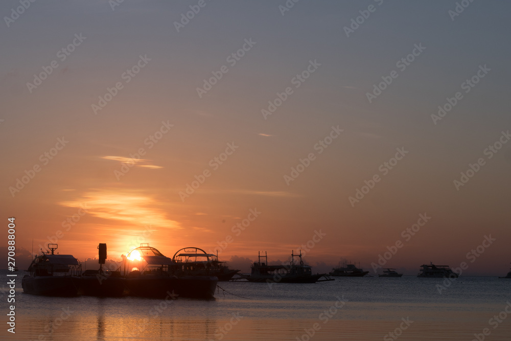 The beach with ships at the dawn