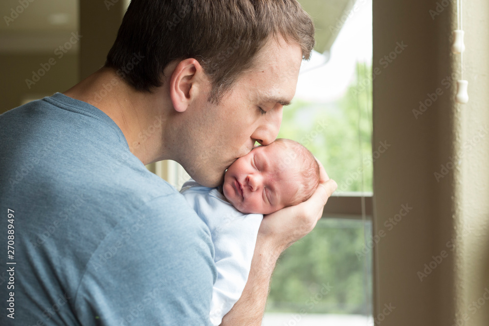 Father kissing his newborn baby Father kissing his newborn baby