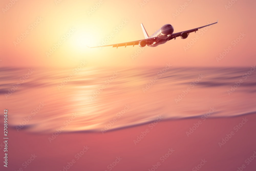 Airplane flying over blur tropical beach with smooth wave and sunset sky abstract background. Airplane flying over blur tropical beach with smooth wave and sunset sky abstract background.