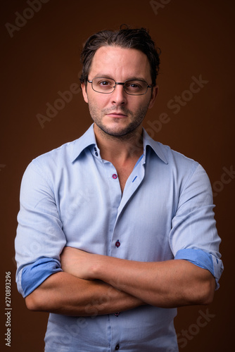 Bild auf Leinwand Studio shot of Italian businessman against brown background
