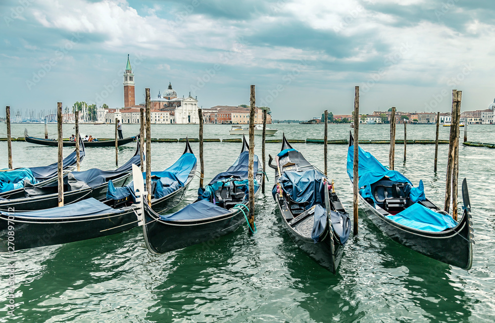 Gondolas in lagoon on the summer sky background, Venice, Italy