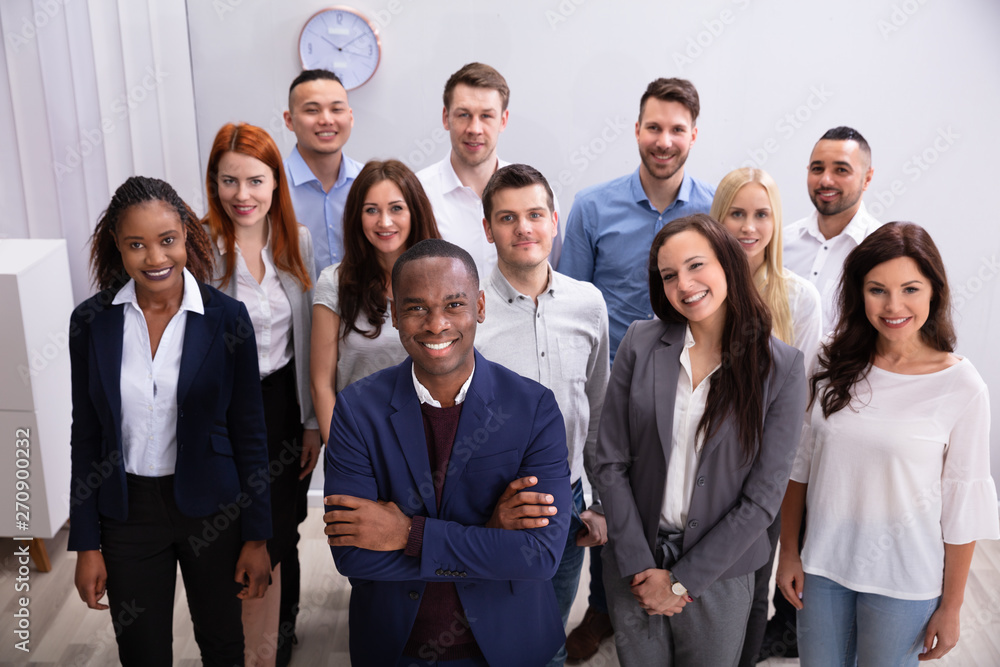 Group Of Smiling Businesspeople Standing In Office Group Of Smiling Businesspeople Standing In Office