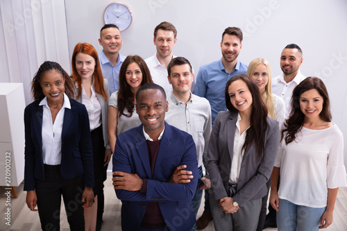 Group Of Smiling Businesspeople Standing In Office