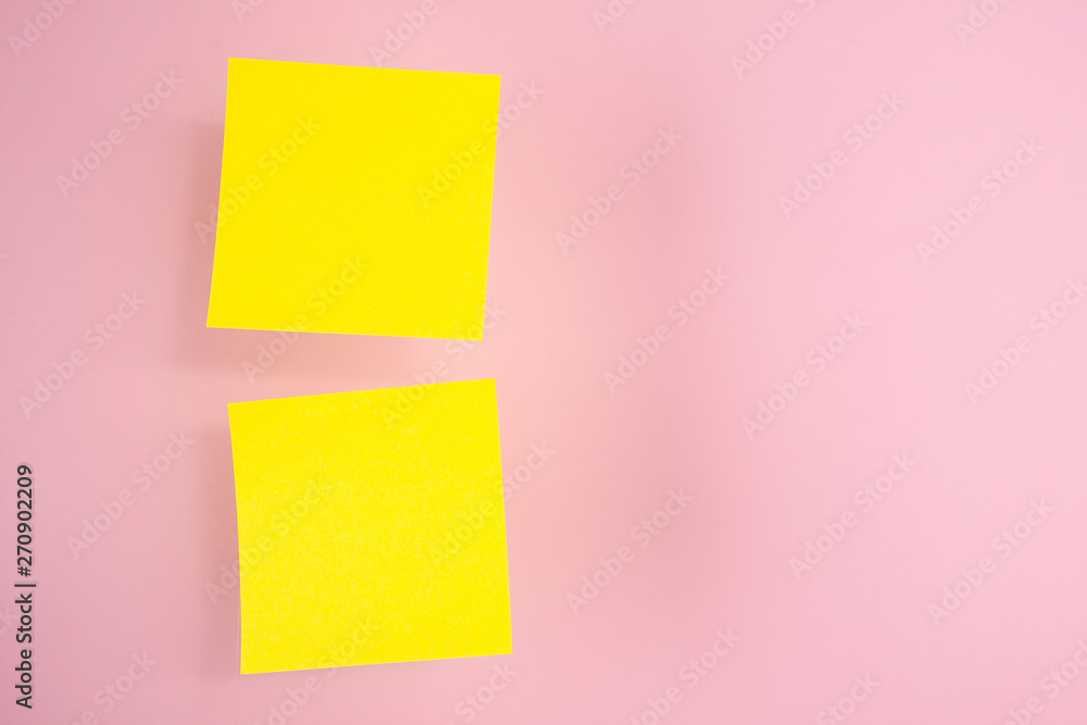 Two yellow paper stickers hanging in the air (levitate) on a pink background Two yellow paper stickers hanging in the air (levitate) on a pink background