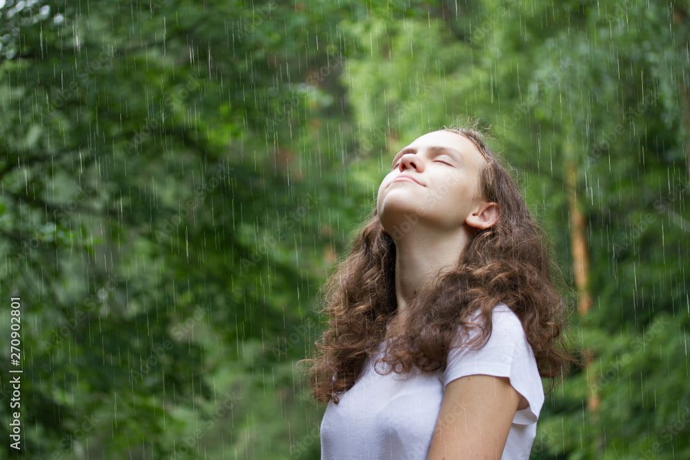 young girl under the rain in a summer park young girl under the rain in a summer park