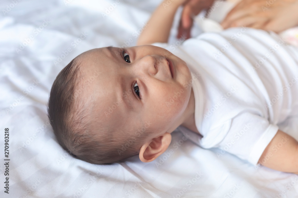 Angry 6 months old baby in bed. Little baby boy feeling uncomfortable and unhappy. Sad baby boy looking at camera. Copy space Angry 6 months old baby in bed. Little baby boy feeling uncomfortable and unhappy. Sad baby boy looking at camera. Copy space