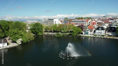 Cinematic Rotating Aerial of Fountain in Park Lake With Typical Nordic Houses in Stavanger Oil Industry Capital of Norway 4k photo