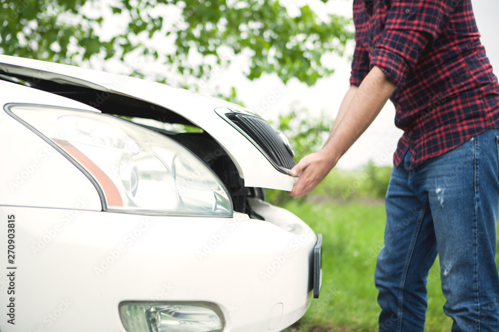 the young man opens the car hood the young man opens the car hood