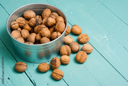 walnuts at tin bowl, old blue table background