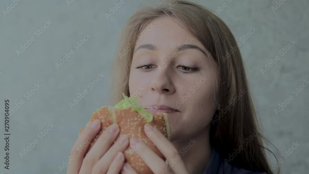 Beautiful girl eats a burger. Fast food restaurant Beautiful girl eats a burger. Fast food restaurant