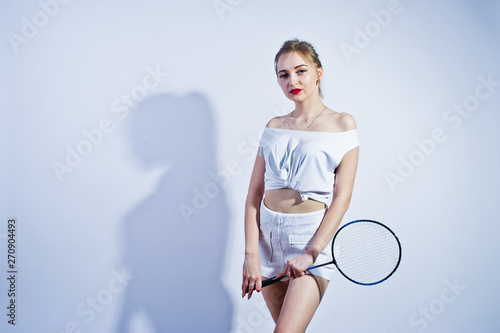 Amazing fit sexy body brunette caucasian girl posing at studio against white background on shorts and top with badminton racket. © AS Photo Family