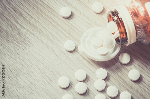 Pills Bottle with Vitamins inside on wood background , zinc , vitamins a, multivitamins.