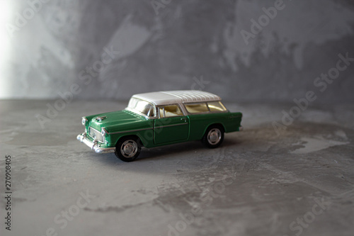 Old vintage white green toy buggy car. Toy transportation concept in macro. Close-up food logistics visualisation.