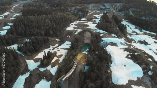 Aerial, orbit, drone shot, around the ski jumping tower, on Vuokatinvaara hill, on a sunny, spring day, in Vuokatti, Sotkamo, Kainuu, Finland photo