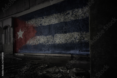 painted flag of cuba on the dirty old wall in an abandoned ruined house.