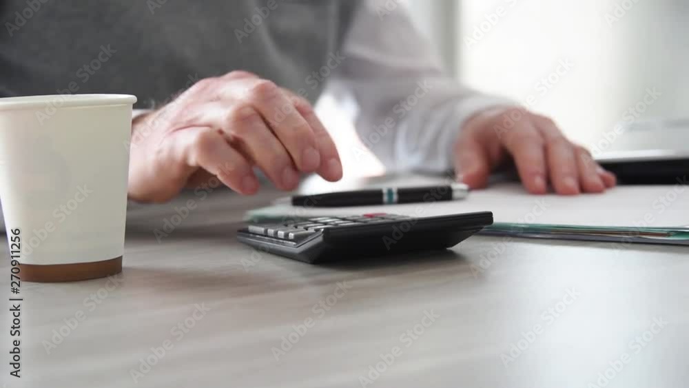 Hand of businessman using calculator Hand of businessman using calculator