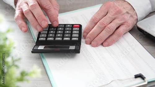 Hand of businessman using calculator