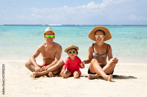 Portrait Of A Family Sitting On Sand At Beach