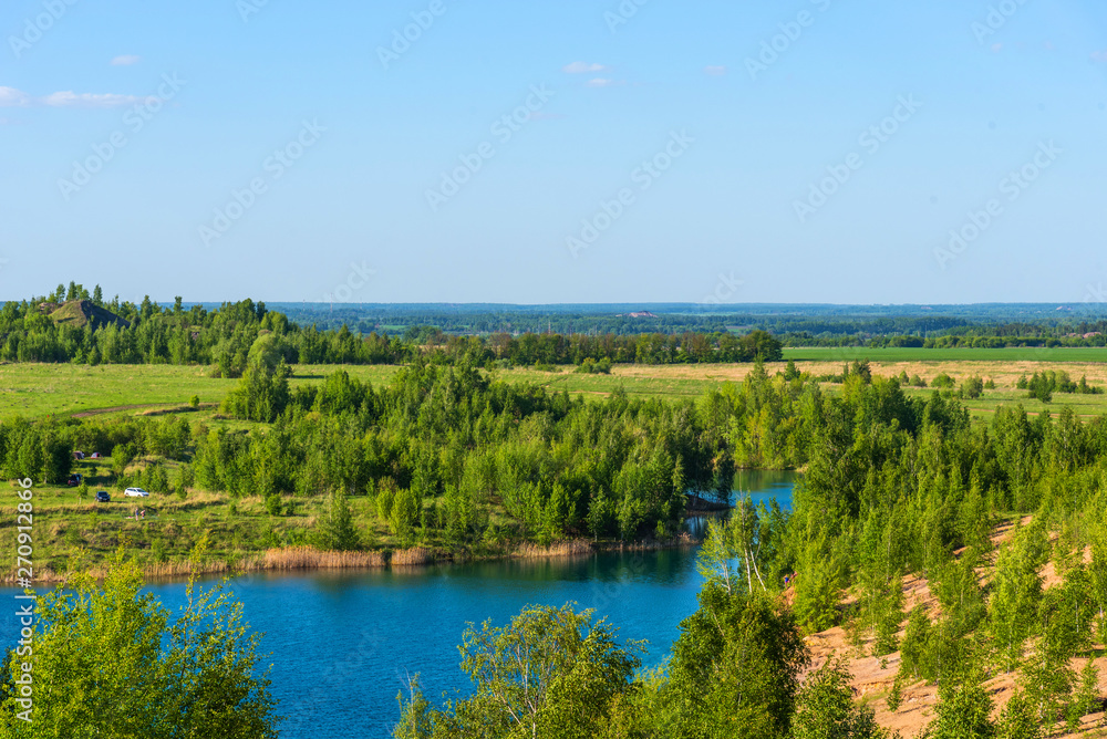 Aerial view of picturesque hills and blue lakes in Konduki, Tula region, Russia. Turquoise quarry in Romantsevo.