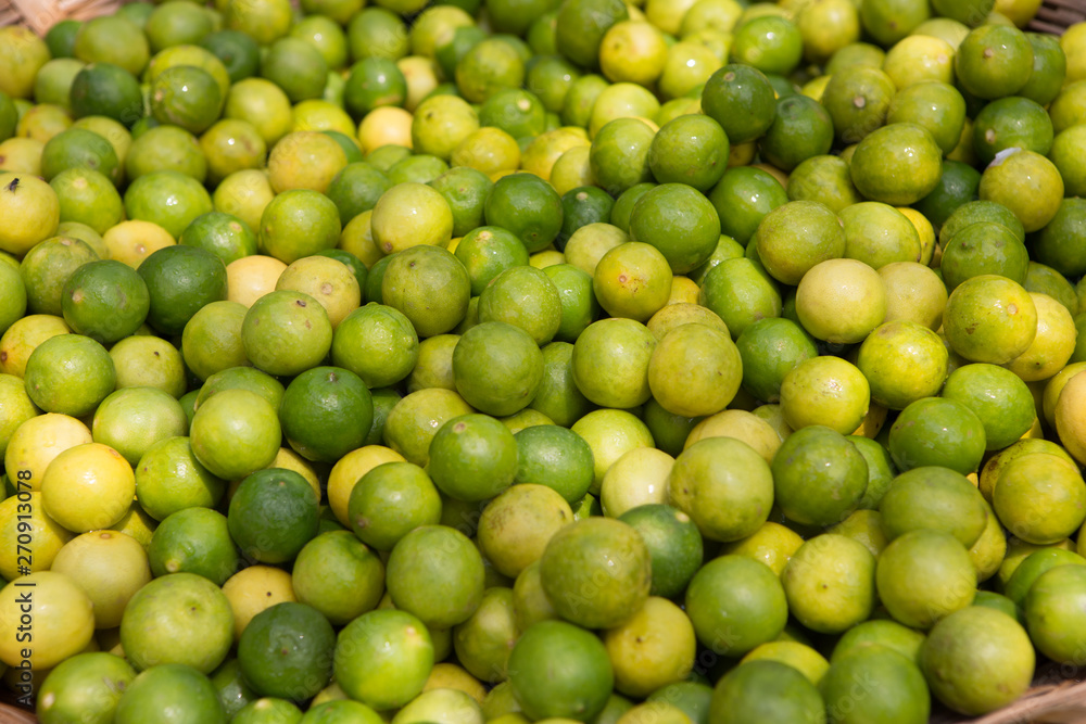 close-up of a basket filled with lemons and limes at a food market somewhere in the south of india close-up of a basket filled with lemons and limes at a food market somewhere in the south of india