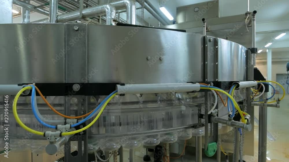 Empty plastic bottles move on automatic conveyor line or belt in water and juice factory or plant production Empty plastic bottles move on automatic conveyor line or belt in water and juice factory or plant production