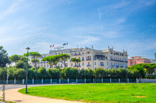 Grand Hotel and square with green lawn in touristic city centre Rimini with blue sky background, Emilia-Romagna, Italy