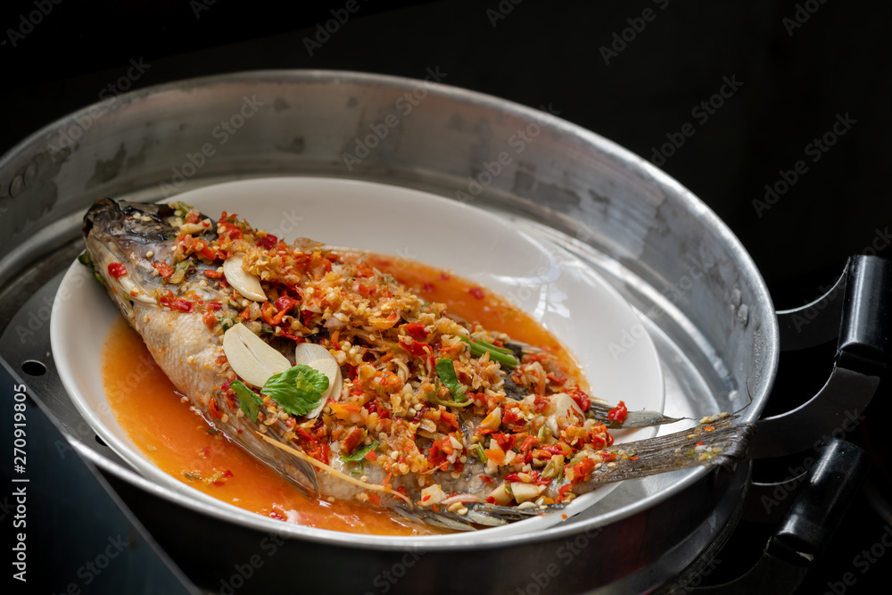 Steamed fish with lime and garlic recipe in steamer pot.