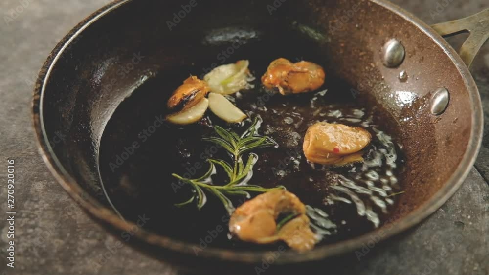 Seafood meal cooking. Mediterranian food recipe. Chef throwing mussels