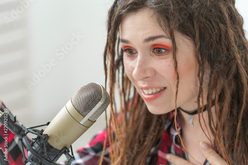 Radio host, blogging and broadcast concept - Modern party girl DJ in bright clothes and with dreadlocks