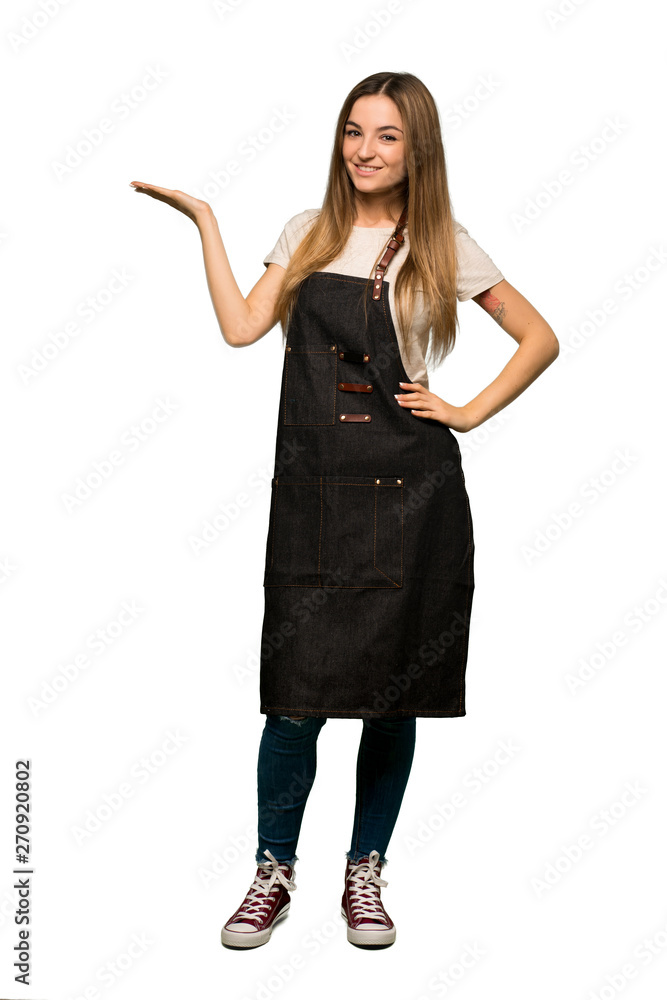 Full body Young woman with apron holding copyspace imaginary on the palm to insert an ad on isolated background Full body Young woman with apron holding copyspace imaginary on the palm to insert an ad on isolated background