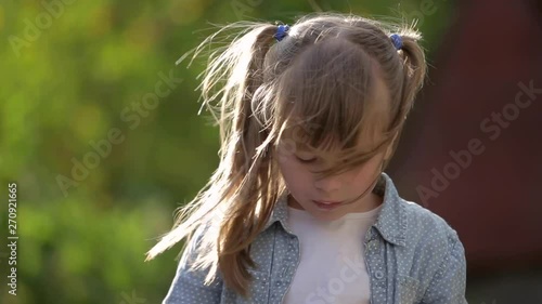 Child girl eating ice-cream with a sponn outdoors. photo