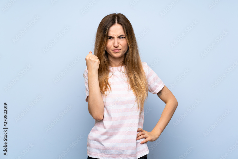 Young woman over isolated blue background with angry gesture Young woman over isolated blue background with angry gesture